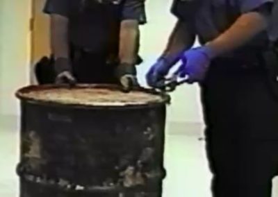 Police opening up a large barrel