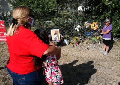 Yolanda Fraser holding granddaughter at vigil