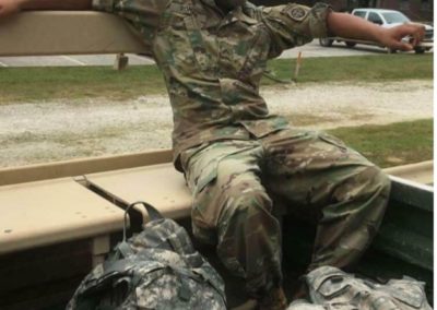 Enrique Roman-Martinez wearing fatigues riding in the back of a truck