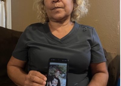 Cathy Delacruz holding a photo of her son Joseph