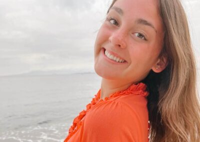 Xana Kernodle in a orange dress by the waterfront
