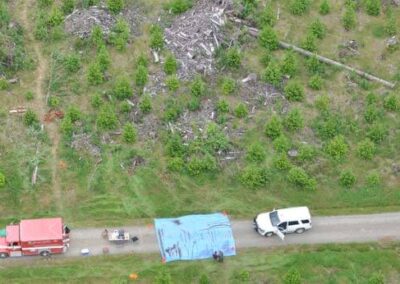 The scene of body recovery, with a blue tarp and sticks on top.