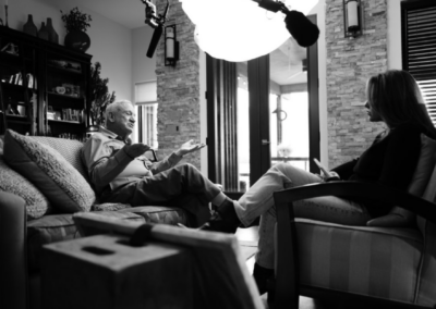 Ashley Flowers and John Ramsey sitting in chairs talking