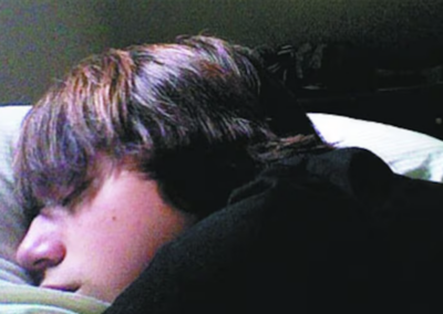 A photo of Blake sleeping in his bed