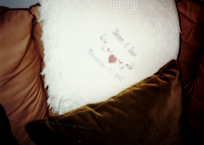 A blanket with Sean and Sue’s wedding anniversary date on a couch in the house.